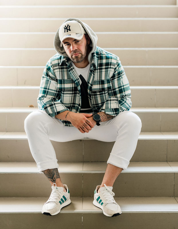 A photo of the coach sitting on a set of stairs.