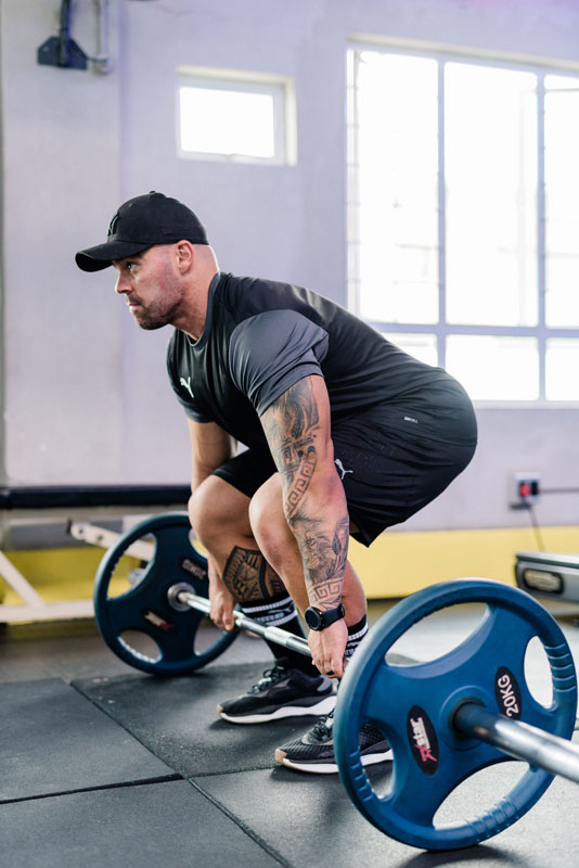 A photo of the coach performing a squat lift.